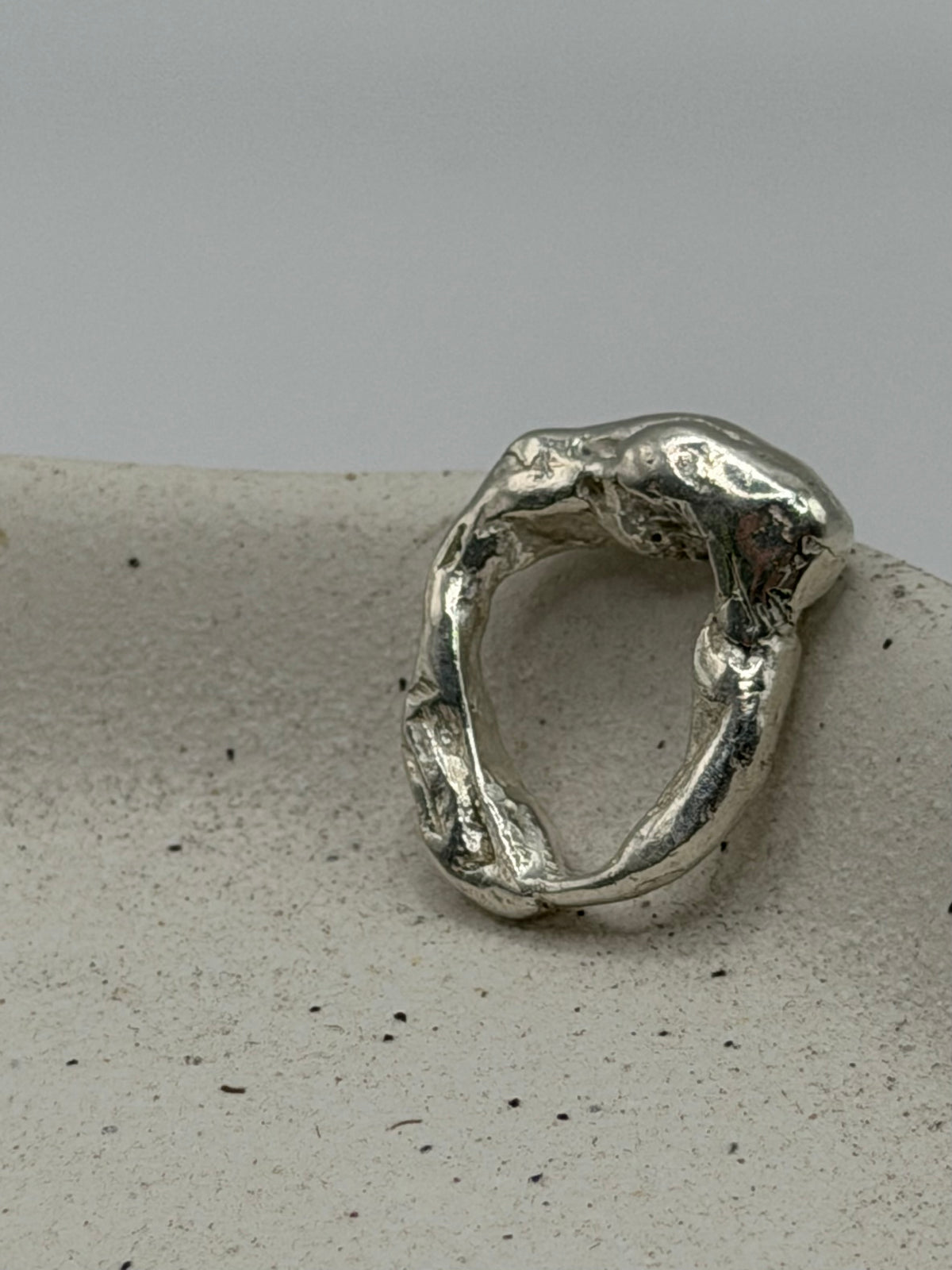 Handmade fine silver molten charm featuring an organic, textured disc with softly rippled detail and a row of beaded silver detail\.