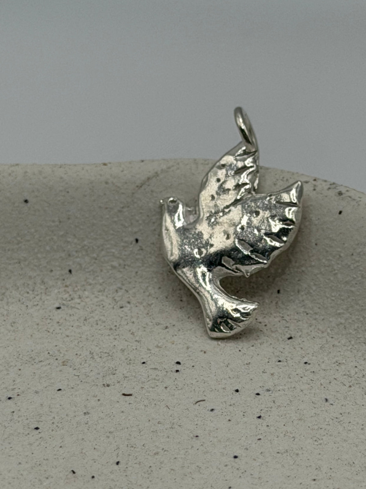 Handmade fine silver Love Lock charm featuring a handstamped dove design on a delicate, textured silver disc, finished with a beaded detail across the top\.