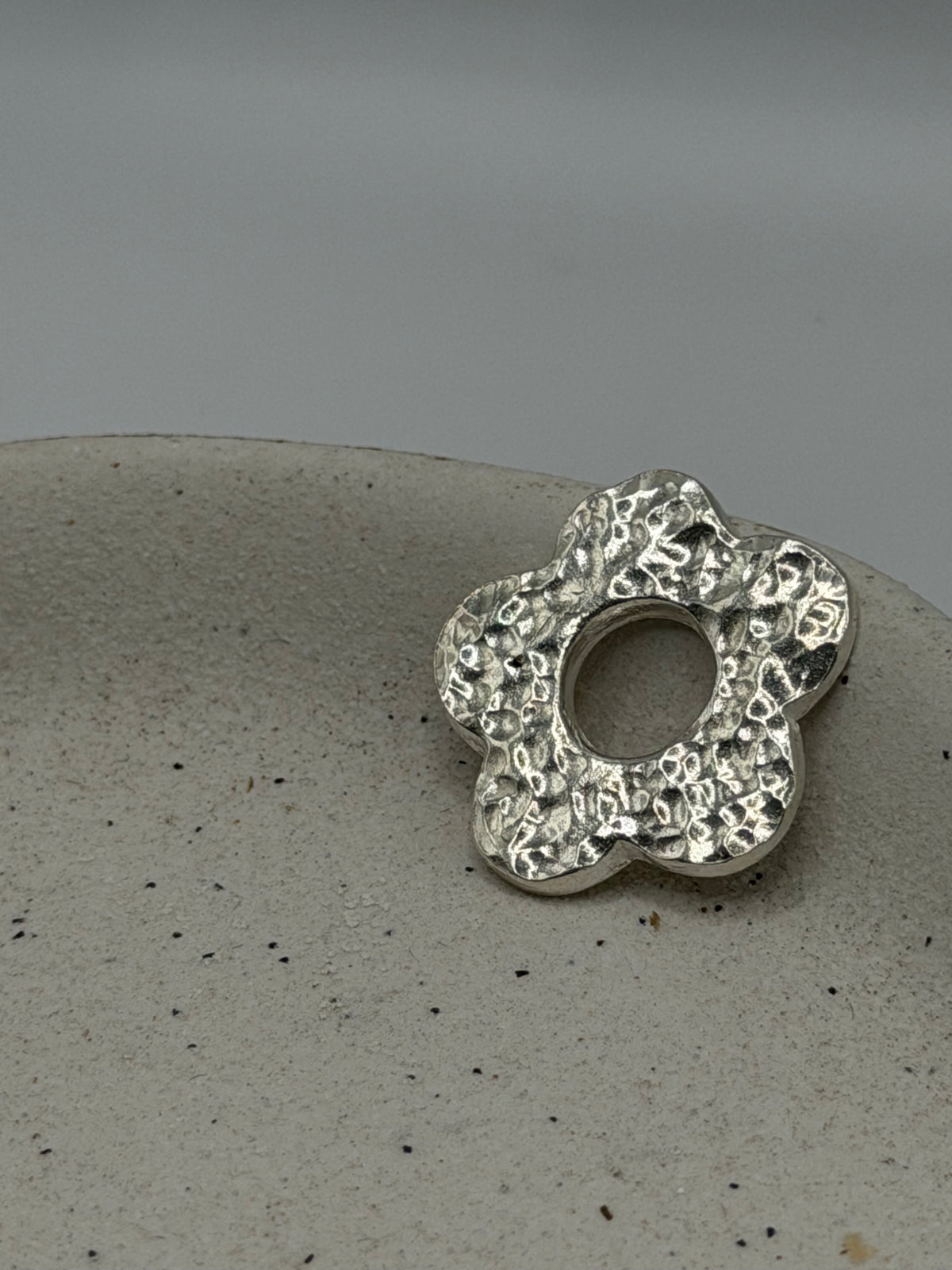 Handmade fine silver Five Petal Flower charm featuring five softly textured petals and an organic, handcrafted finish\.