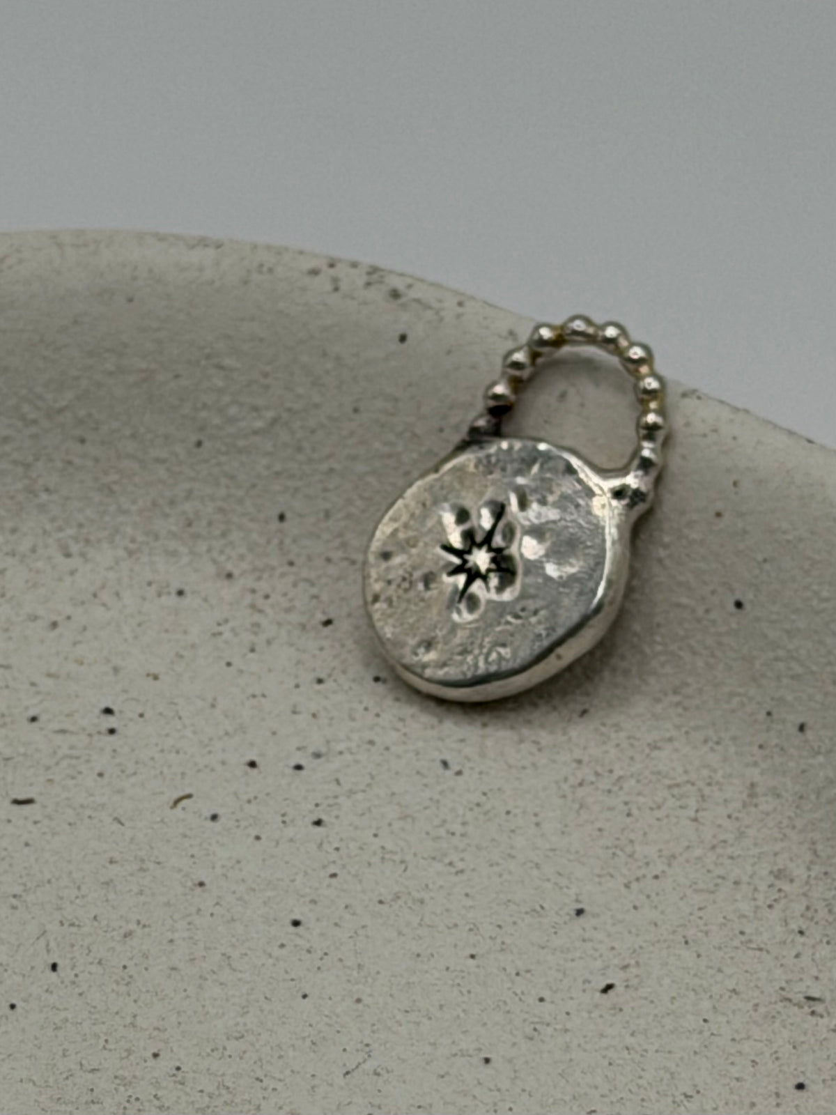 Handmade fine silver Love Lock charm featuring an organic, textured disc with softly rippled detail and a row of beaded silver detail.
