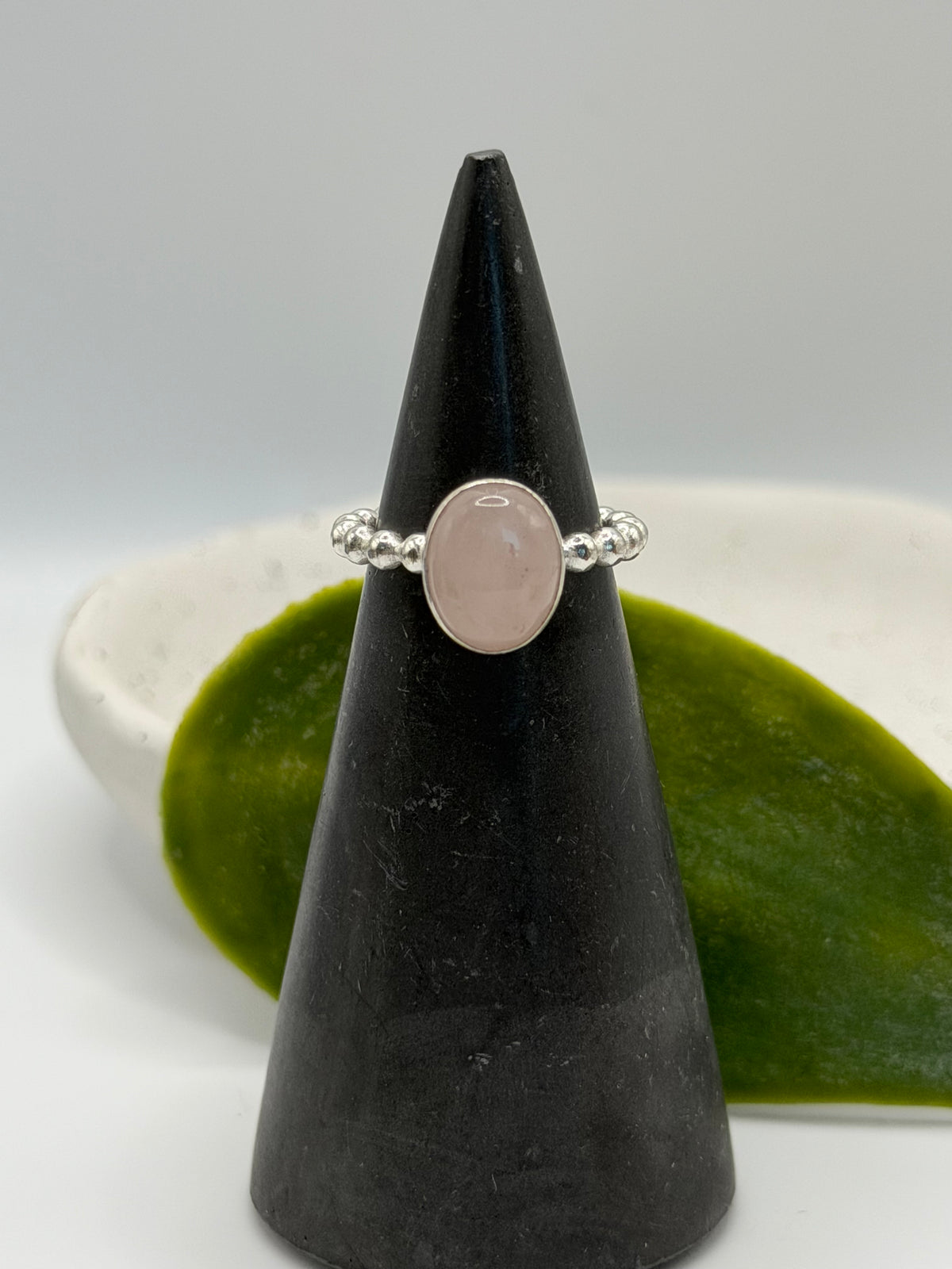 One-of-a-kind rose quartz bobble ring from the Stone + Silver collection by Wild One Jewellery, featuring a pale pink oval cabochon set in a sterling silver band with decorative silver bobble details, displayed in a blue velvet ring box.