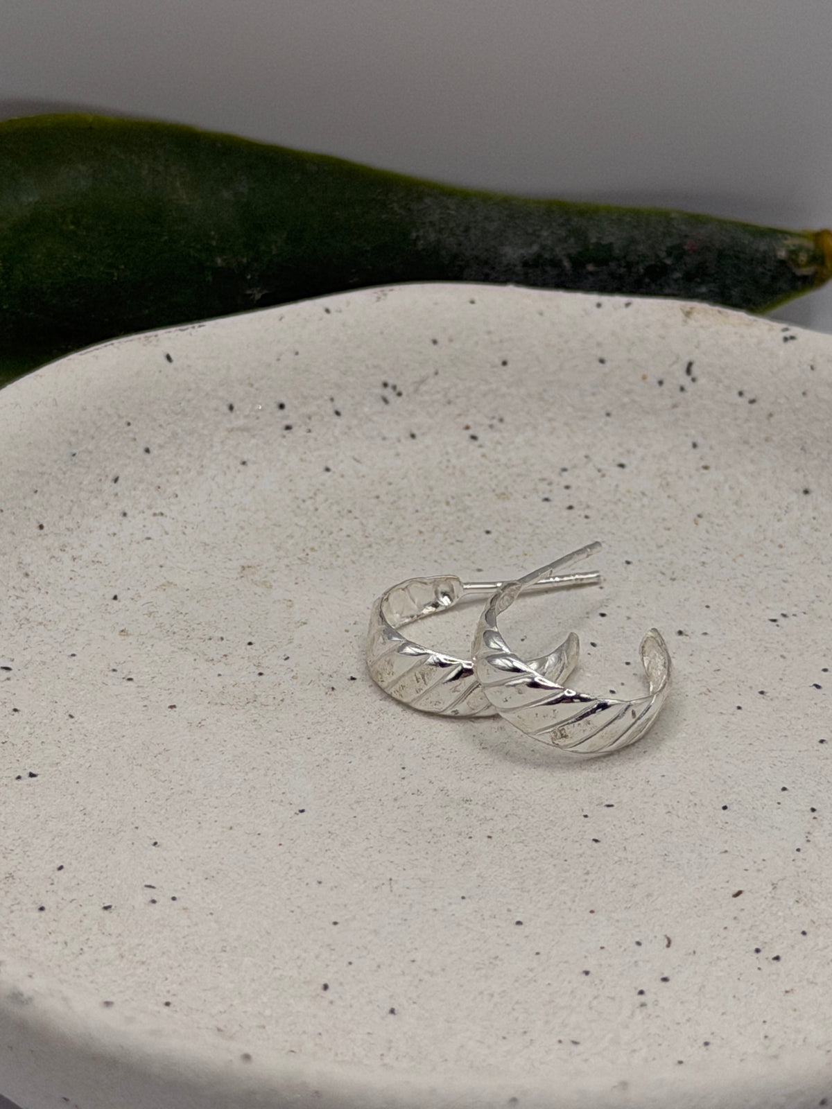 Pair of textured sterling silver Twist Hoops handcrafted in small batches by Wild One Jewellery.